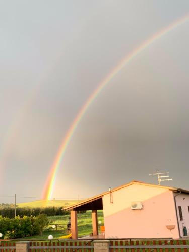 a rainbow in the sky over a house at Agriturismo Mimosa in Rispescia