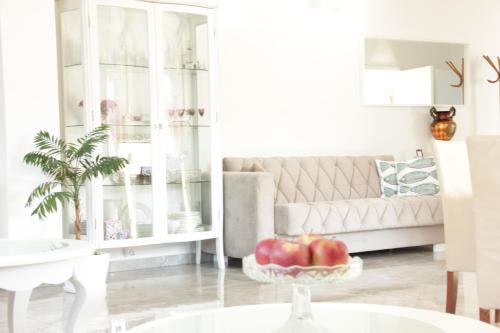 a living room with a couch and a bowl of apples on a table at Lux House Olga in Ruma