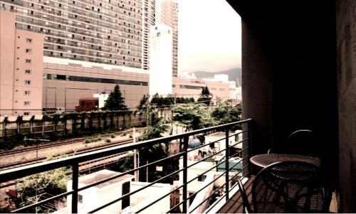 balcón con silla y vistas a la ciudad en TRT Hotel en Busan