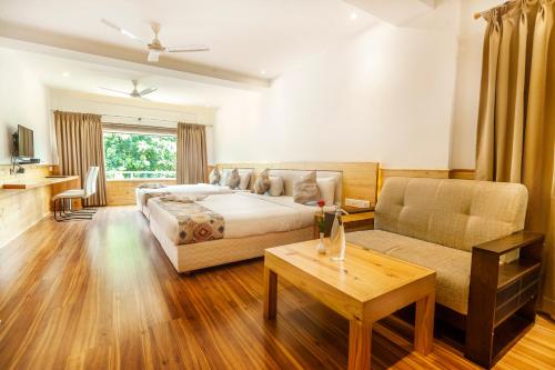 Kāladi的住宿－精英宮酒店，一间卧室配有一张床、一张沙发和一张桌子