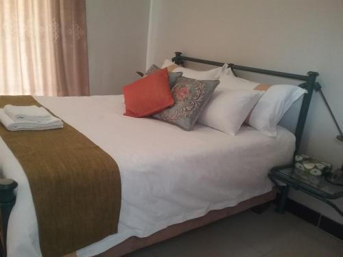 a large bed with many pillows on it at The Star B&B in Jwaneng