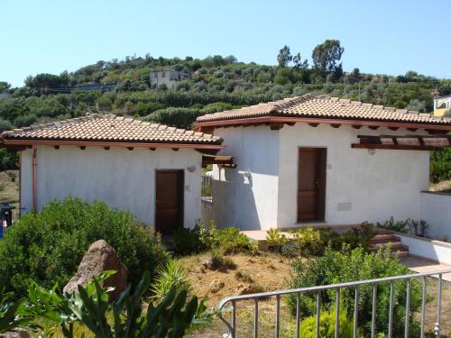 a white house with a hill in the background at Affittacamere Valverde di Naitana Rita in Alghero