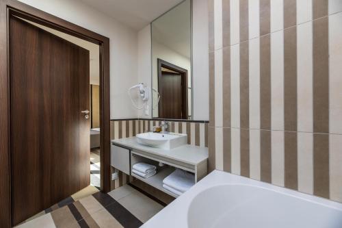 a bathroom with a sink and a mirror at Grand Baltic Dunes Hotel & SPA in Palanga
