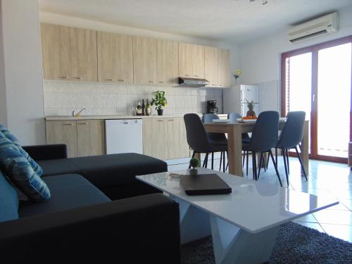a living room with a couch and a table and a kitchen at Apartment 3 in Zadar