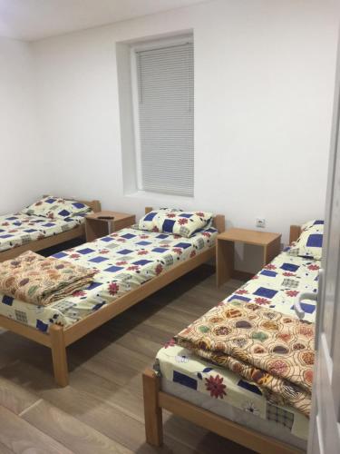 a group of three beds in a room at Apartmani LazaDora in Boljevac