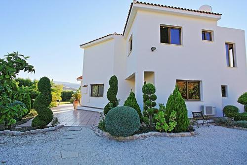 a large white house with a bunch of bushes at Golden Valley Villa in Skoulli