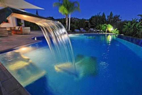 a swimming pool with a fountain in the middle of it at Golden Valley Villa in Skoulli