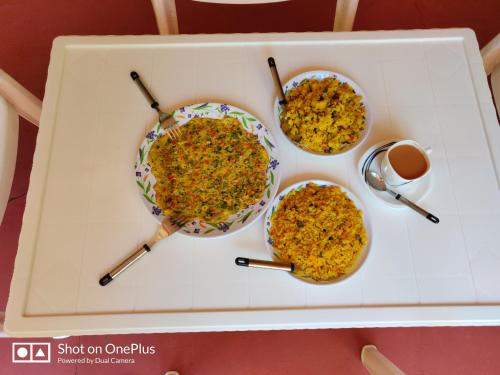 drie kommen eten op een dienblad met eetstokjes bij Leela's Cottage in Lonavala