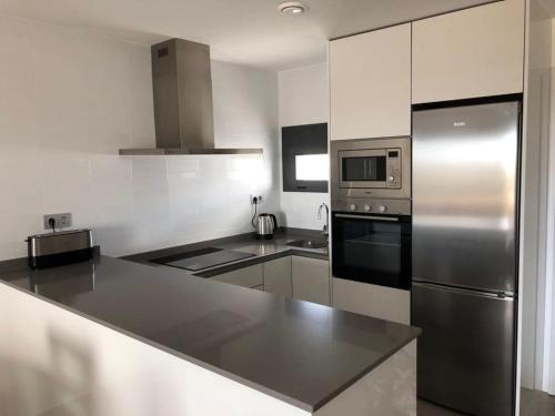 a kitchen with a stainless steel refrigerator and appliances at Penthouse Lamar 43.11 in Pilar de la Horadada