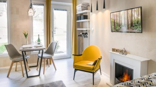sala de estar con mesa, sillas y chimenea en Luxury Studio 24 en Győr