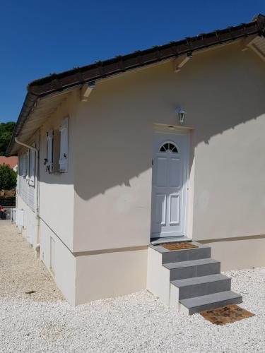a white building with a blue door and stairs at Studio Bleu - Parc Astérix - Mer de Sable - Villepinte - Aéroport CDG in Vémars