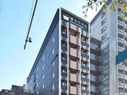 a tall building with a crane in front of it at Henn na Hotel Fukuoka Hakata in Fukuoka