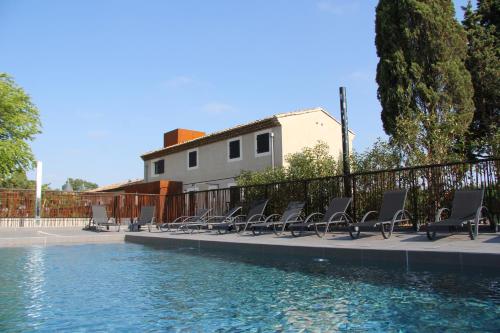 卡爾卡松的住宿－Hotel Pont Levis - Franck Putelat，一组椅子坐在游泳池旁