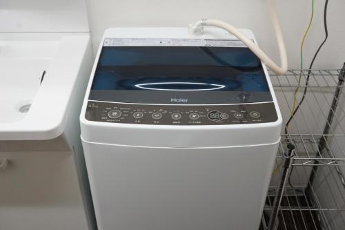 a washing machine is sitting in a kitchen at Fujinokura Tiny Fort in Fujiyoshida