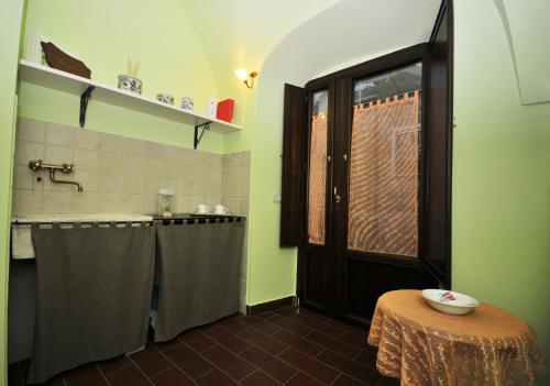 baño con paredes verdes, lavabo y mesa en Residenza Bove Incoronato, en Bovino