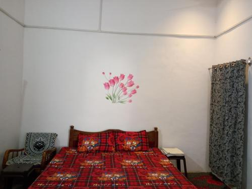 a bedroom with a bed with a red blanket at Holiday Home Stay in Khajurāho