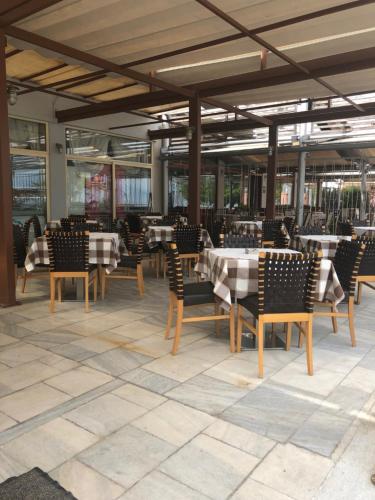 a dining area with tables and chairs in a restaurant at Hotel Kypreos in Kamena Vourla