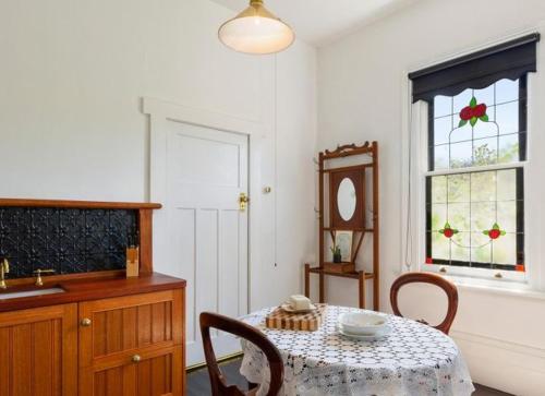 a dining room with a table and a window at Oakdene Heritage Accommodation in Saint Marys