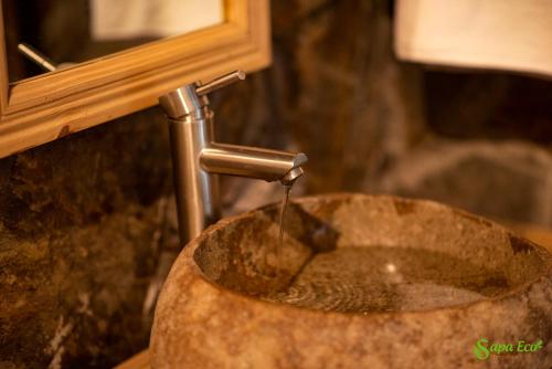 een wastafel in de badkamer met water uit een kraan bij Sapa Eco Bungalows & Spa in Sa Pa