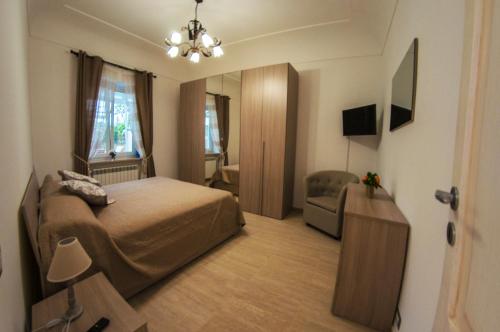 a bedroom with a bed and a chair and a mirror at La Primavera in Anacapri