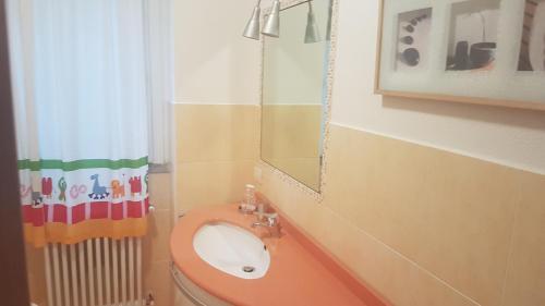 ein Bad mit einem WC, einem Waschbecken und einem Spiegel in der Unterkunft GIRASOLE in Lierna