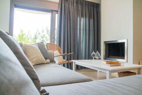 uma sala de estar com um sofá e uma televisão em Legno Bianco em Stalida
