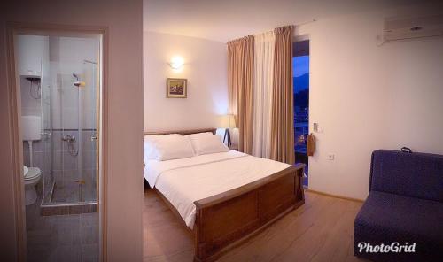 a bedroom with a bed and a bathroom with a shower at Guest house Villa Slavica in Sveti Stefan