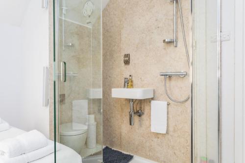 a bathroom with a shower and a sink and a toilet at Beautiful pied-a-terre to explore London in London