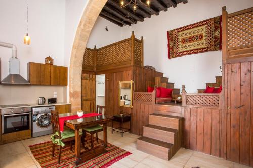 a kitchen with wooden cabinets and a table in a room at CasaLindos Festa in Lindos