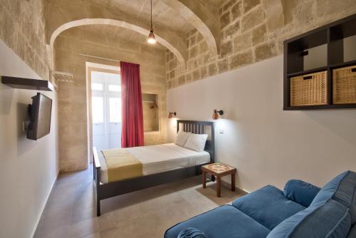 a living room with a bed and a couch at Vallettastay Classic Apartments in Valletta