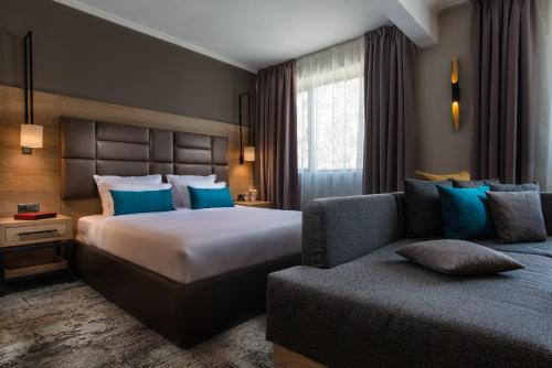 a hotel room with a bed and a couch at The Stay by Aston Hotel Central Square - Free Compliments - Free Wi-Fi - TOP LOCATION - Nearby Paid Parking in Plovdiv