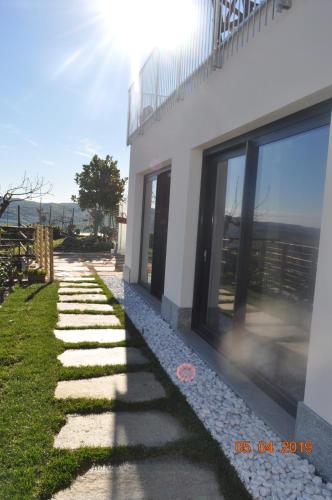 a building with a stone pathway next to a building at Casa Tina Holiday Home in Diano dʼAlba