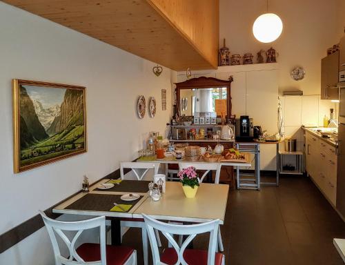 eine Küche mit einem Tisch und Stühlen im Zimmer in der Unterkunft Chalet-Gafri - BnB - Frühstückspension - Service fast wie im Hotel in Wilderswil