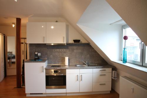 uma cozinha com armários brancos e um lavatório em Fewo Lorri em Dorsten