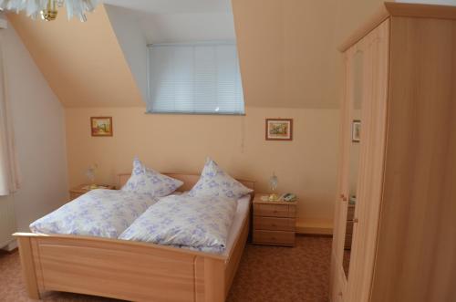 Pension & Ferienwohnung "Villa Agnesruh" في باد إلستر: غرفة نوم بسرير ومخدات ونافذة