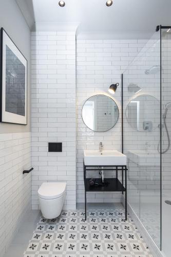 a white bathroom with a toilet and a sink at Apartamenty przy Monte Cassino in Sopot
