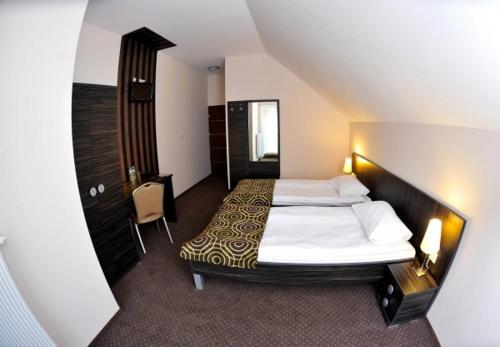 a hotel room with a large bed and a chair at Hotel Sulbin in Garwolin