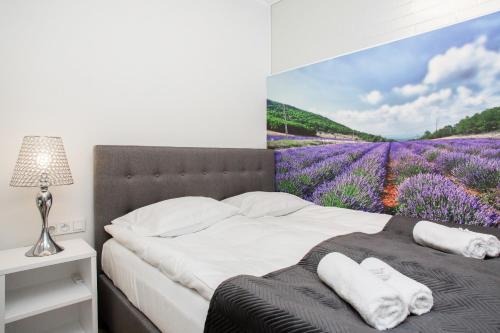 ein Schlafzimmer mit einem Wandbild eines Lavendelfeldes in der Unterkunft Apartments Warsaw Przyokopowa by Renters in Warschau