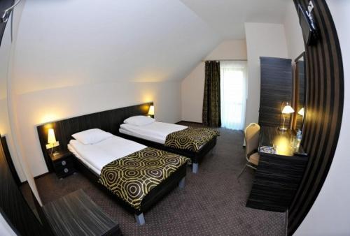 a hotel room with two beds and a mirror at Hotel Sulbin in Garwolin