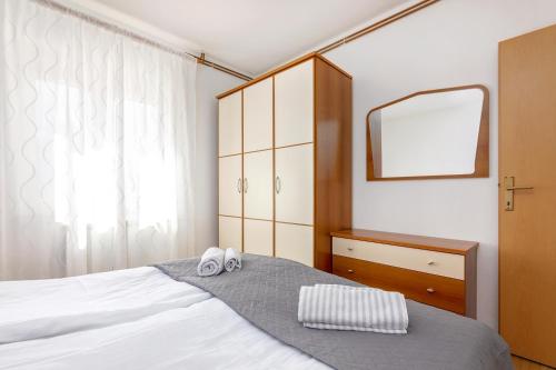 a bedroom with a bed with a mirror and two slippers at Apartments Santos in Vrsar