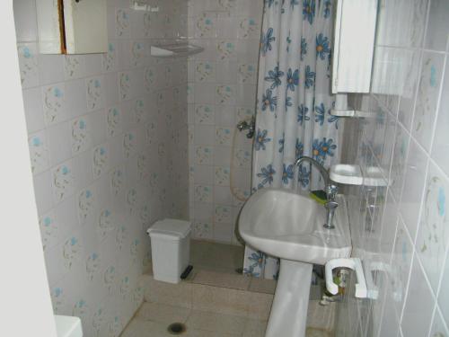a white bathroom with a sink and a shower at Villa Mina in Potistika
