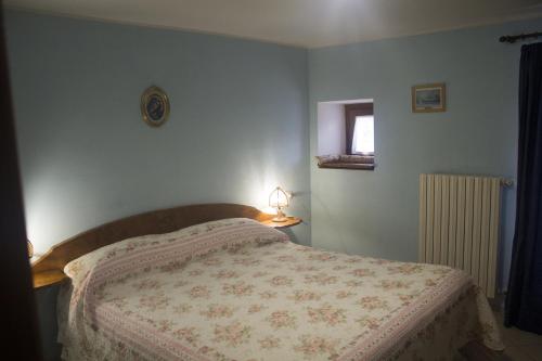 a bedroom with a bed with a blanket on it at Anticarua B&B in Opi