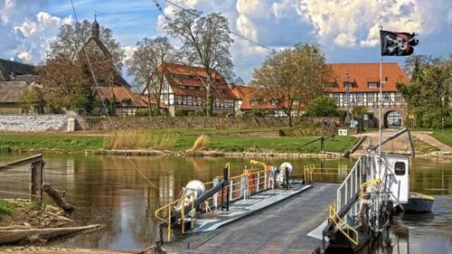 a boat is docked in the water on a river at Apartment Ferienwohnung Emmerthal auch für Monteure FeWo in Emmerthal