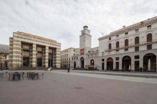 a city square with a clock tower and buildings at Locanda delle Mercanzie in Brescia