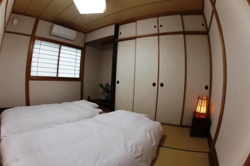 Un pat sau paturi într-o cameră la Stay Omihachiman Ekimae Inn