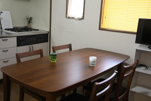 a kitchen with a wooden table with chairs and a stove at Stay Omihachiman Ekimae Inn in Omihachiman