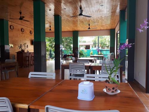 Hiep Hoa Resort في موي ني: غرفة طعام مع طاولة وكراسي خشبية
