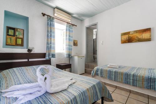 a bedroom with two beds and a towel animal on the bed at Villa Christina in Spetses