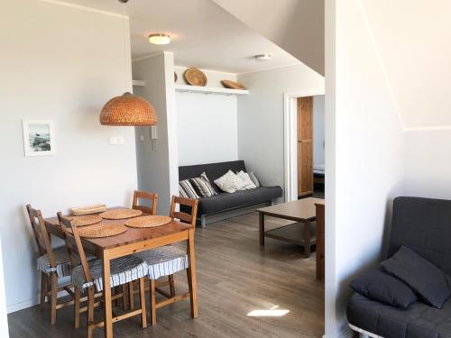 een eetkamer en een woonkamer met een tafel en een bank bij Widok in Jastrzębia Góra