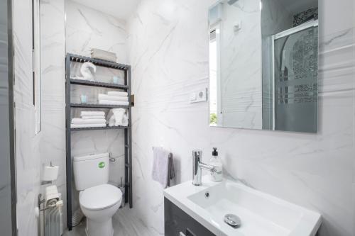 a white bathroom with a toilet and a sink at 14 Mirasierras in Madrid